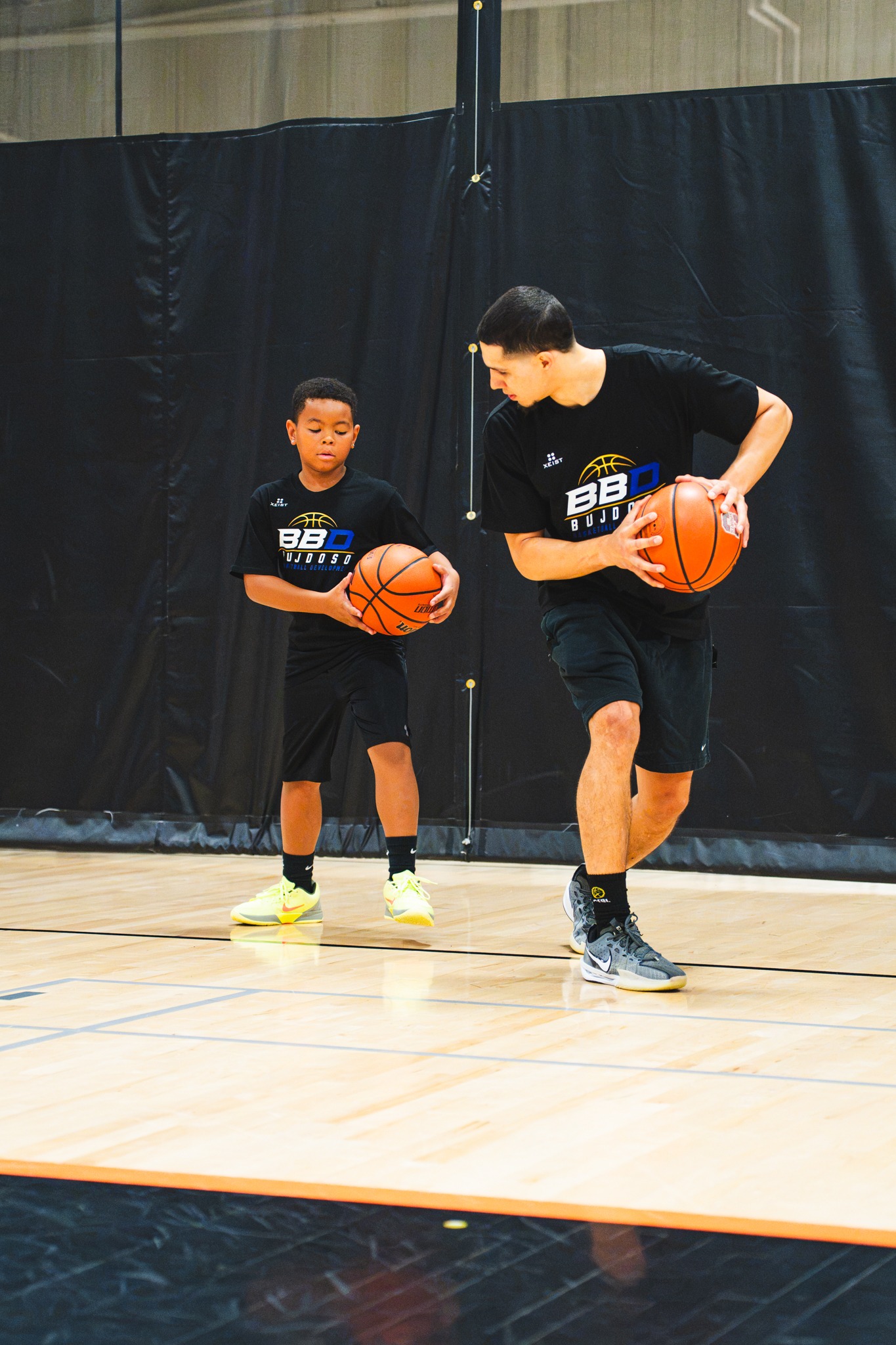 BBD coach demonstrating ball-handling footwork with a player